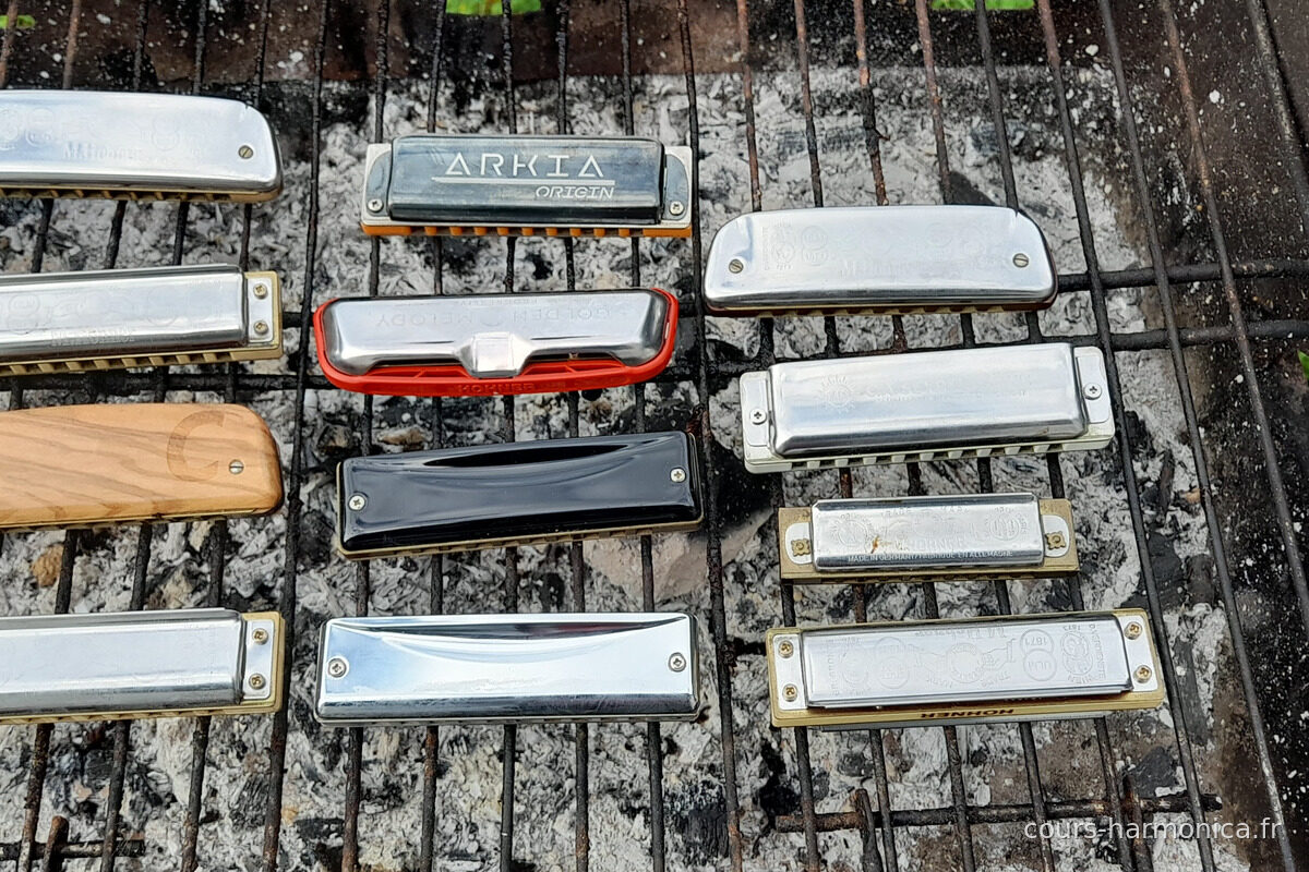 Une douzaine d'harmonicas diatoniques alignés sur une grille de barbecue (photo Alain Messier)